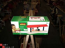 Brio Perron met twee passagiers, voor bij trein spoor,