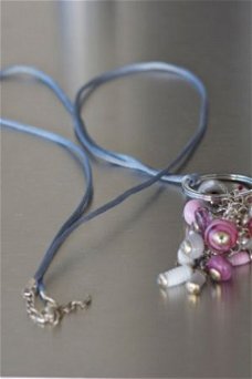 Lange suede ketting met tros roze wit tint glasbeads/kralen.