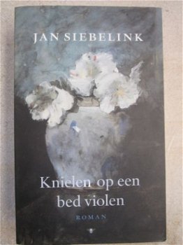 Knielen op een bed violen. Jan Siebelink. - 1