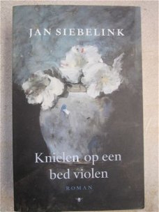 Knielen op een bed violen. Jan Siebelink.