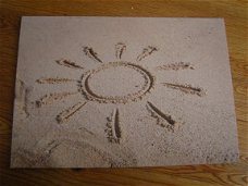 kaart met afbeelding van een getekende zon in het zand