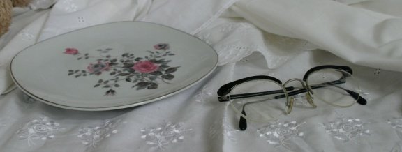 een bordje / schaaltje met 'zilveren' randje en bloemmotief - 0