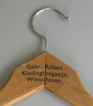 een oude kledinghanger met opdruk van de winkel (ook osi) - nr. 1