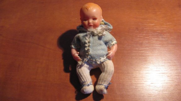 Baby popje met kleren en een muts uit de jaren 50. - 2