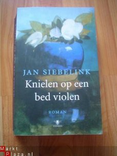 Knielen op een bed violen door Jan Siebelink