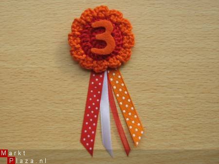 ** Gehaakte verjaardagsbroche met lintjes (oranje) - nr. 1