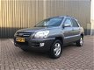 Kia Sportage - 2.0 CRDi Adventure HR 4X4 / GRIJS KENTEKEN / AIRCO / LEDER / 6 BAK / ELEKTRISCH PAKKE - 1 - Thumbnail