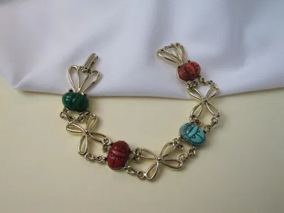Armband goudkleurig met kunststof scarabees en bloemschakels 18 cm - nr. 1