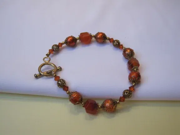 Armband goudkleurig oranje/rood aurora glas kralen 19.5 cm. - nr. 1