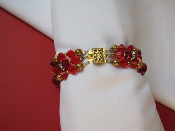 Armband goudkleurig drie strengen met rood kristal en spacers 18.5 cm - Afbeelding 2