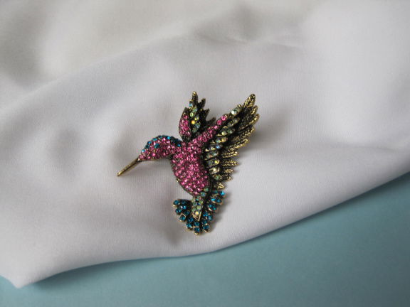 Broche goudkleurig antieklook kolibri vogel met roze blauw aurora rijnsteentjes 5.3x4.9 cm. - nr. 1