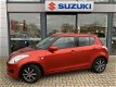 Suzuki Swift - 1.2 Comfort | Airco | Lichtmetalen Velgen | Leder Stuurwiel | Stuurwiel Bediening | - 1 - Thumbnail