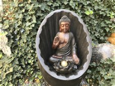 Beeld van boeddha met handgebaar zittend in een tempel