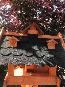 Een groot houten vogelhuis op standaard, een villa voor vogels - 2