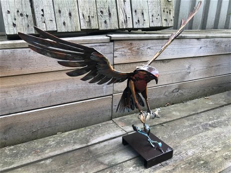 Een metalen kunstwerk van een adelaar die een vis vangt, ''IRON EAGLE'' - 4