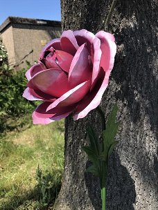 Een kunstwerkje, grote roze roos gemaakt van metaal,roos