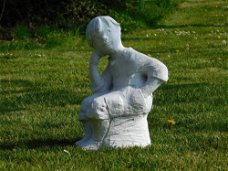 Beeld zittende jongen  ,vol steen , tuinbeeld