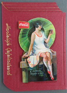 FELICITATIE --- Coca Cola dame op een boek