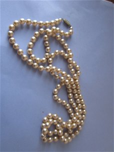 Lange halsketting met geknoopte parels en slotje met strass