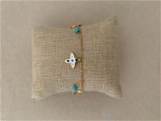 Gouden bedel armband met wit en turquoise klavers