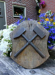 Houten bord met symbool van de mijnbouw: hamer en beitel