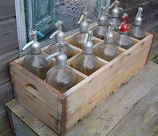 Brocante houten krat met spuitflessen